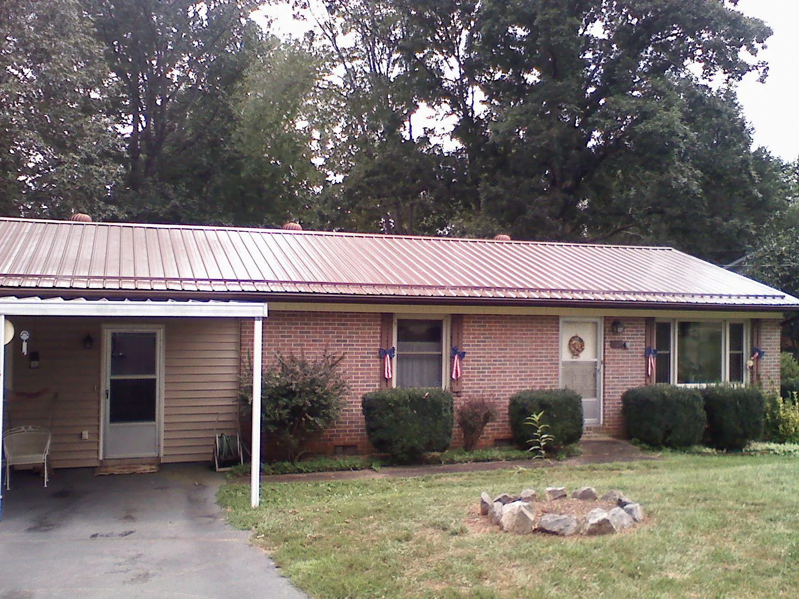 Bronze metal roof and carport on a brick ranch home — Roof Repair work by our crew in Syracuse